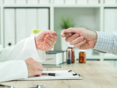 Doctor taking medical insurance card from patient