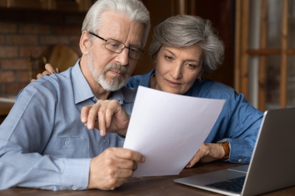 Old age married couple do paperwork engaged in reading document