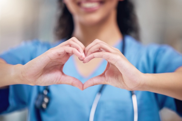 Happy woman, doctor and heart shape hands for love in healthcare or life insurance at the hospital. Female person or medical professional showing hand loving emoji, symbol or sign gesture at clinic